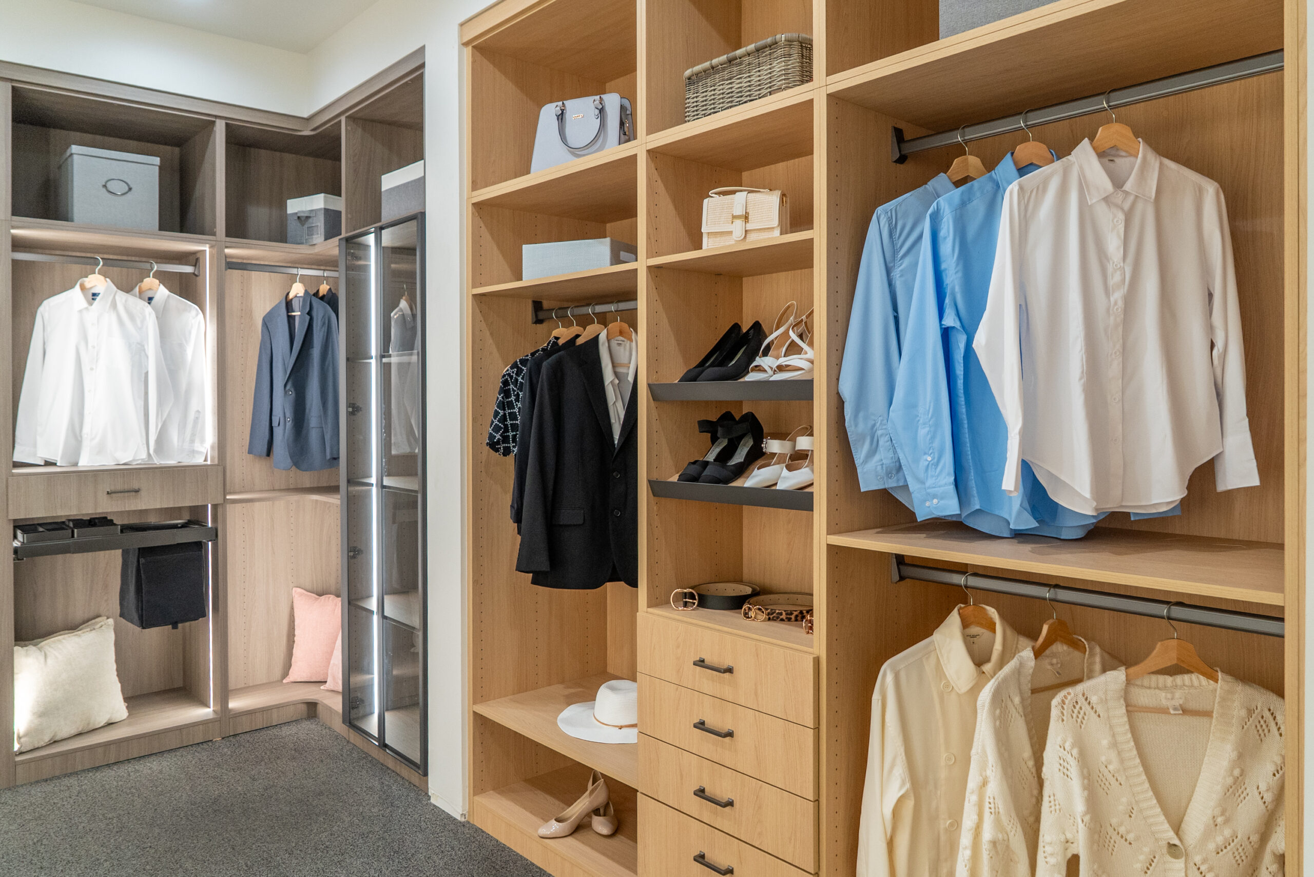 Organized walk-in closet with shelves, hanging clothes, and shoes.