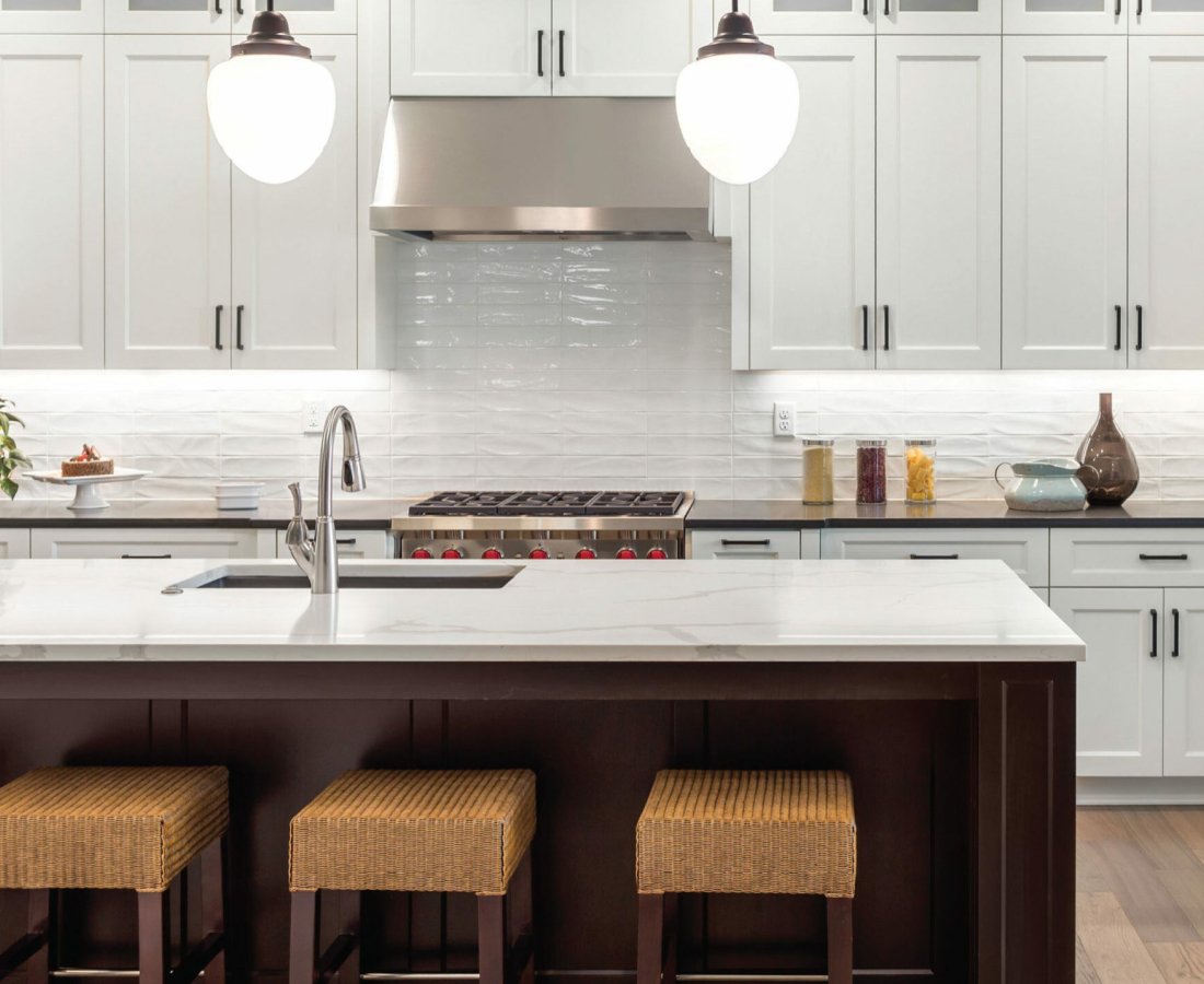 Modern kitchen with white cabinets and a large island with seating.