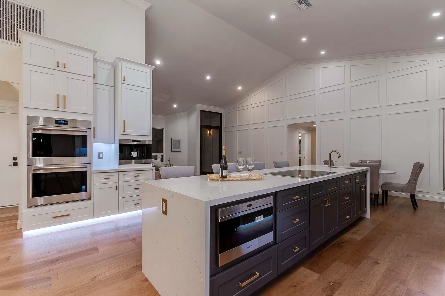 Modern kitchen with white and navy cabinets and a large island.
