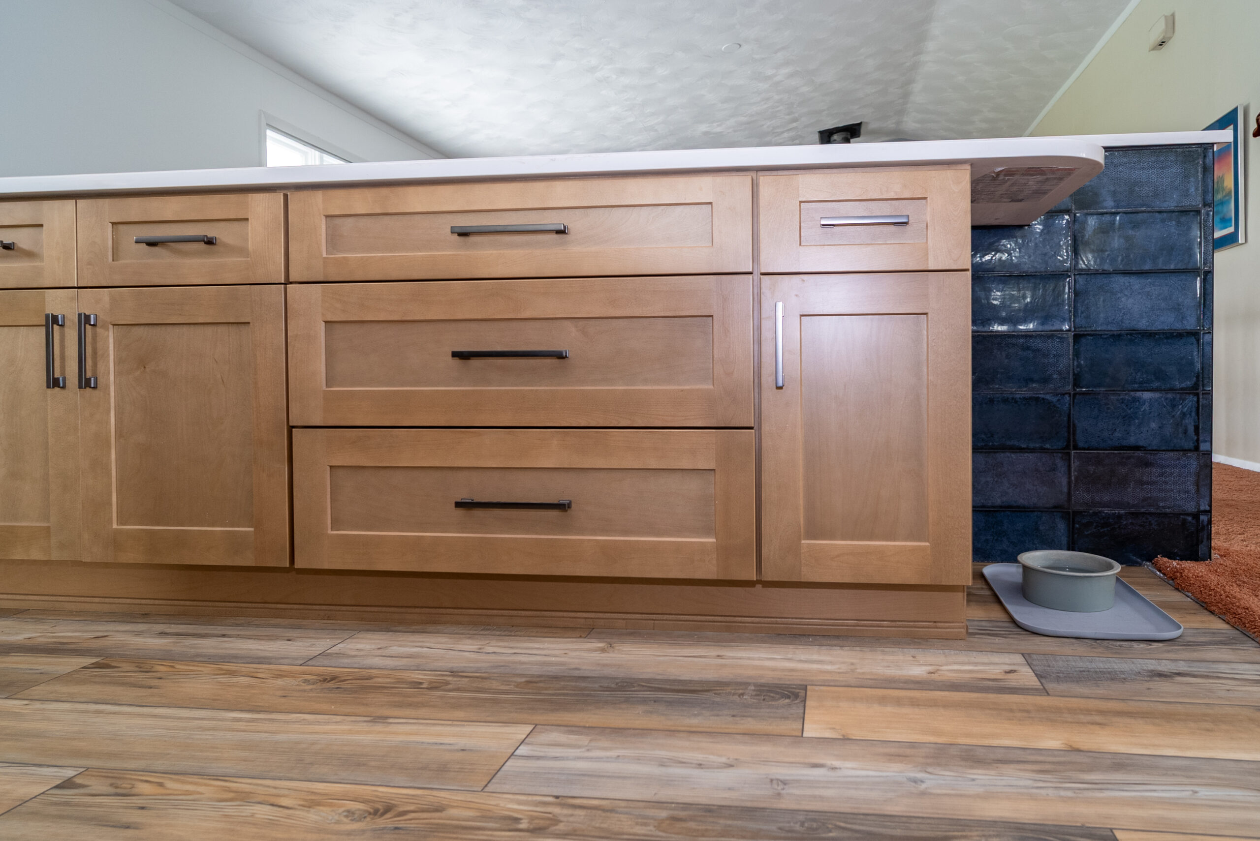 Modern wooden kitchen cabinets with sleek black handles.