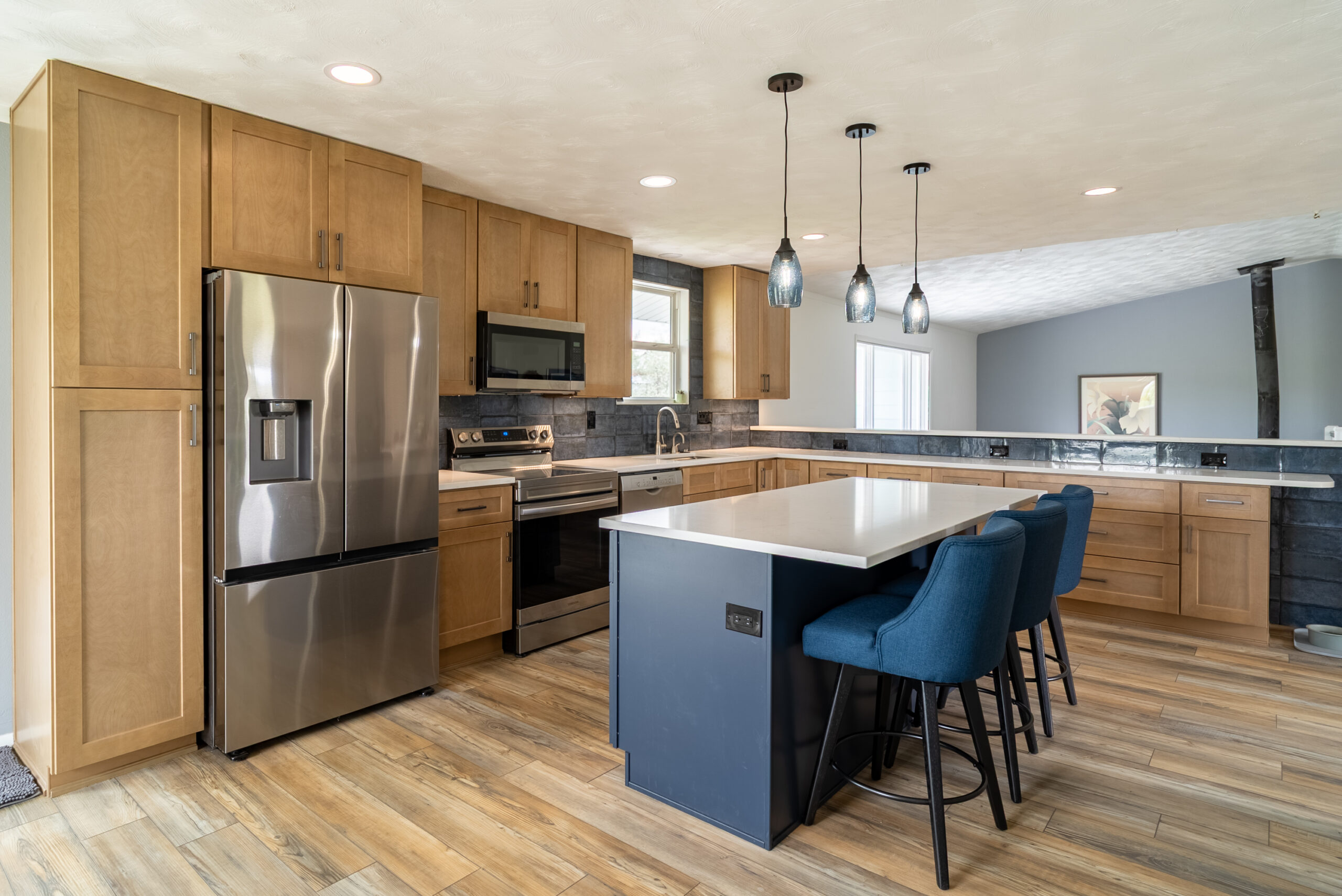 Modern kitchen with wooden cabinets and a blue island with bar stools.