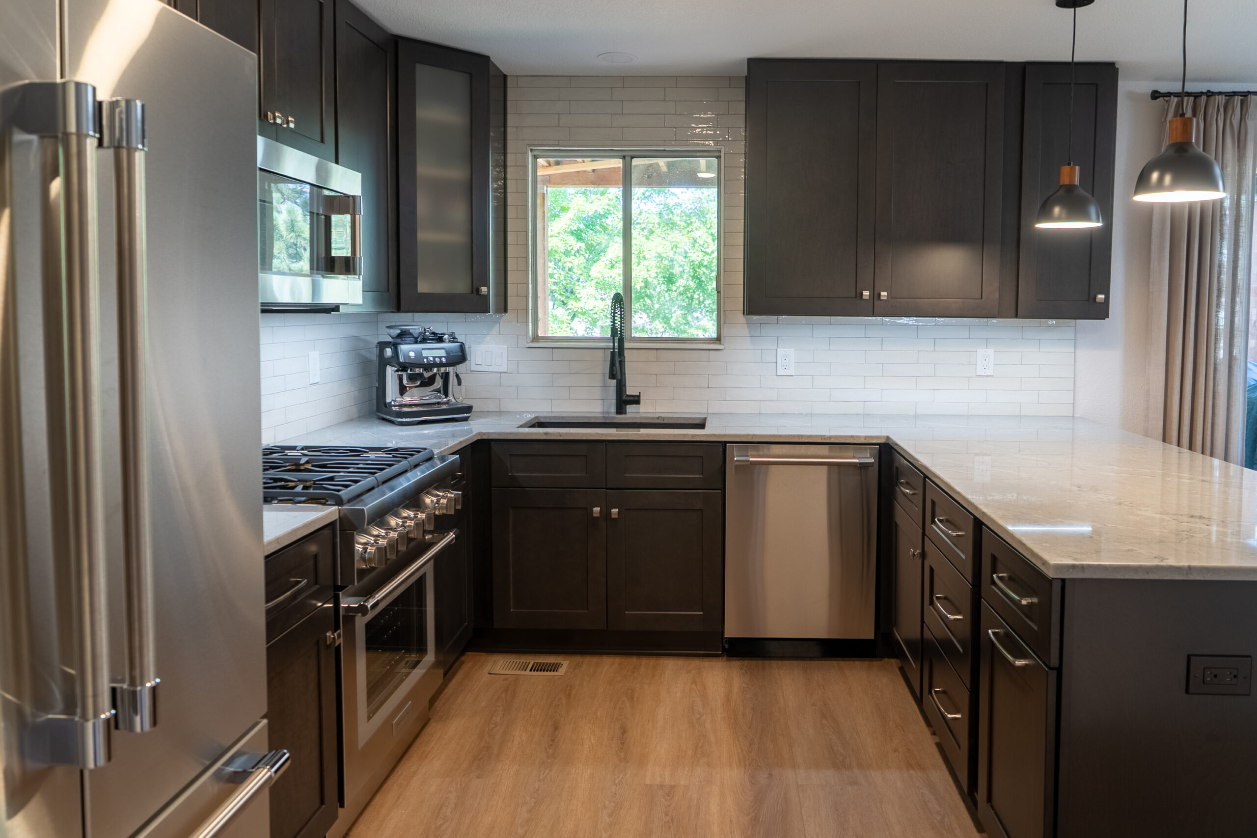 Modern kitchen with dark cabinets and stainless steel appliances.