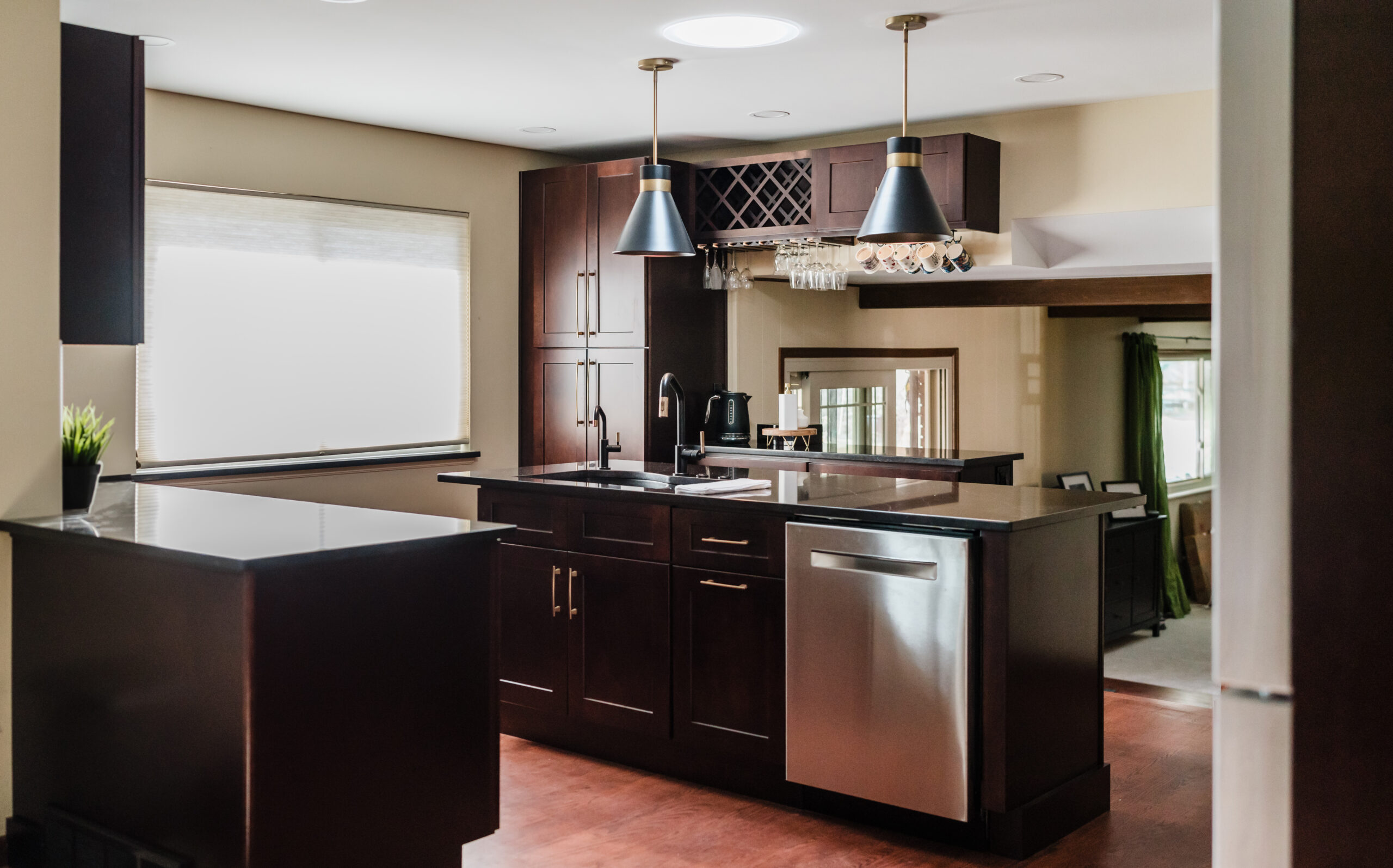 Modern kitchen with dark wood cabinets and stainless steel appliances.