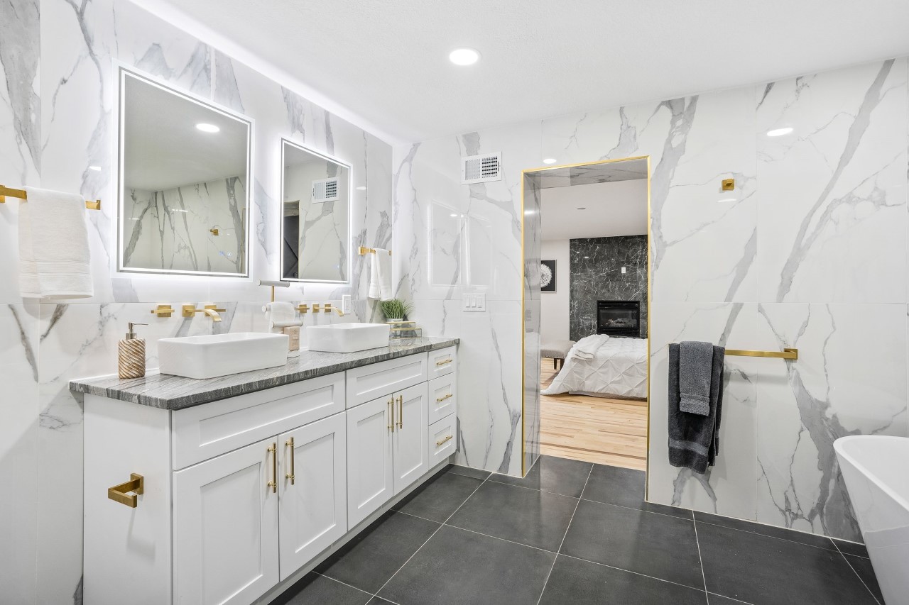 Bright modern bathroom with white cabinets and large mirror.